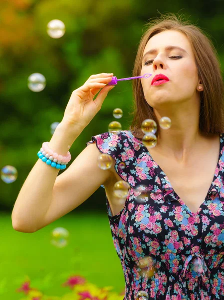 Женщина пускает мыльные пузыри, веселится — стоковое фото