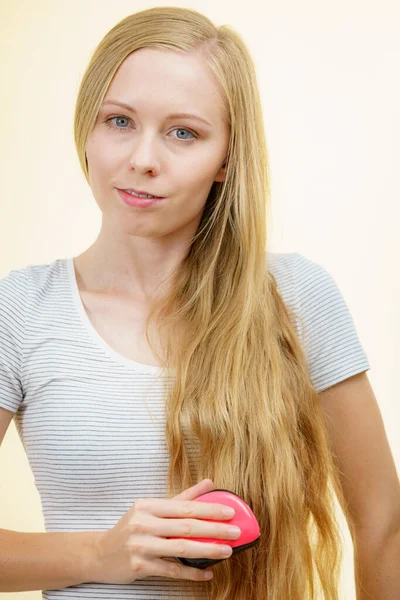 Blondynka dziewczyna szczotkowanie jej długie włosy — Zdjęcie stockowe