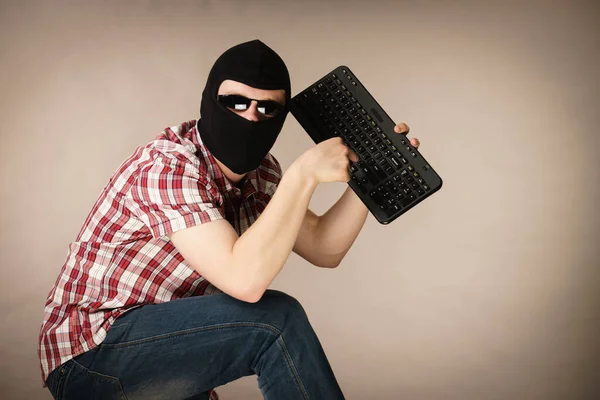 Man dragen balaclava bedrijf toetsenbord — Stockfoto