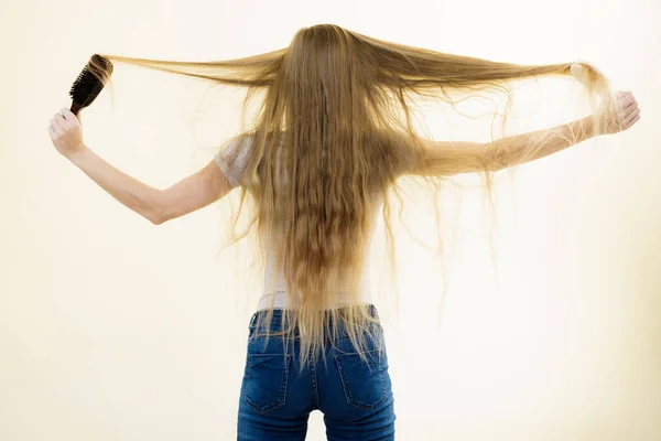 Blond flicka borsta hennes långa hår — Stockfoto