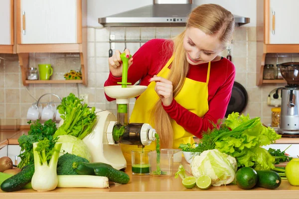 Mulher na cozinha fazendo suco de smoothie vegetal — Fotografia de Stock