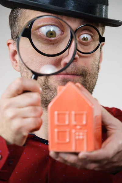 Man magnifying red house — Stock Photo, Image