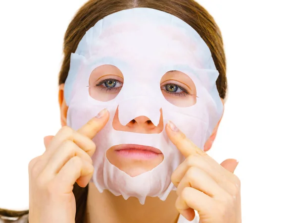 Woman applying sheet mask on face — Stock Photo, Image