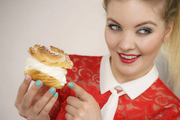 Lächelnde Frau hält Windbeutel-Kuchen in der Hand — Stockfoto