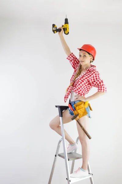 Mädchen benutzt einige Elektrowerkzeuge für die Arbeit zu Hause — Stockfoto