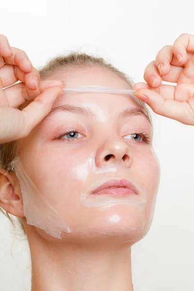 Mujer quitando la máscara de la piel facial . —  Fotos de Stock