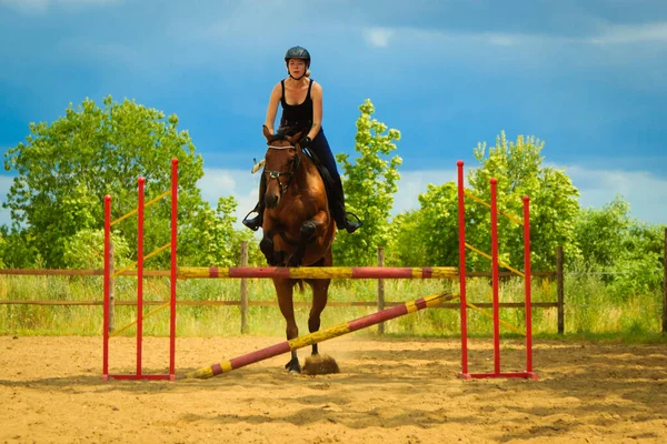 Jockey gadis muda melakukan lompat kuda melalui rintangan — Stok Foto