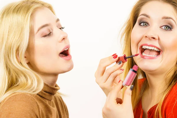 Mujer aplicando su pintalabios amigo en los labios —  Fotos de Stock