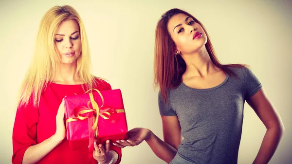 Dos hermosas mujeres con caja de regalo roja — Foto de Stock