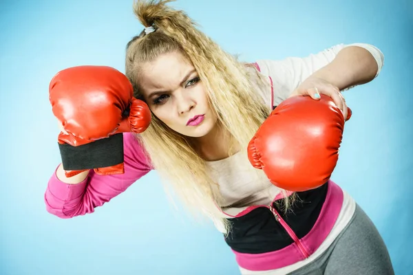 スポーツ面白い女性は赤のボクシングの手袋を着用し 戦うためにしようとする スタジオ撮影青の背景 — ストック写真