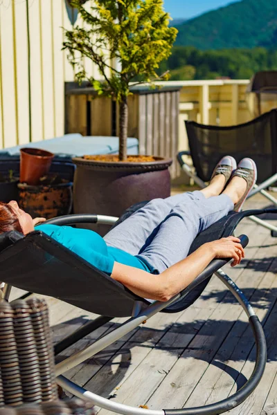 在阳光下放松 成年女子在阳台上的甲板躺椅上休息 度假别墅 — 图库照片