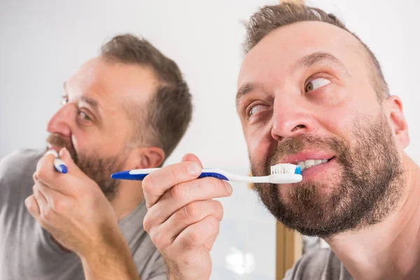 Uomo Adulto Lavarsi Denti Guardando Suo Specchio Del Bagno Durante — Foto Stock