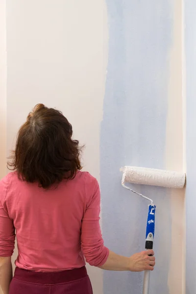 妇女用滚筒刷在墙上喷漆 家庭翻新概念 — 图库照片