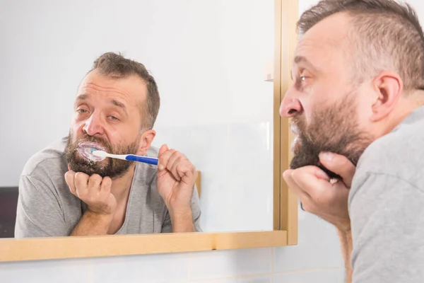 Homem Adulto Escovando Dentes Olhando Para Espelho Banheiro Durante Rotina — Fotografia de Stock