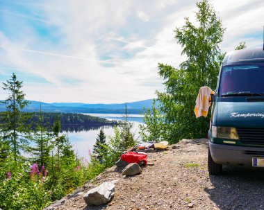 Camper van motor home on fjord lake shore in summer. Camping on norwegian nature. Holidays and travel in caravan. clipart