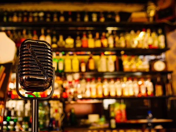 Bar Räknare Med Mikrofon Och Suddig Bakgrund Med Olika Alkoholflaskor — Stockfoto