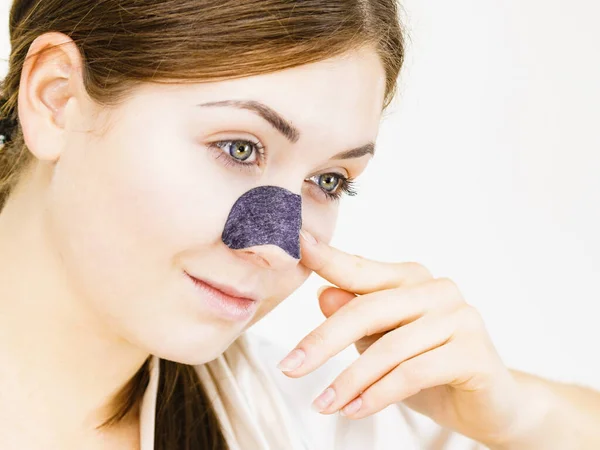 女性の鼻の上にクリアアップストリップを適用すると 毛穴の洗浄繊維マスクを使用して 肌の色を気にする女の子 美の治療だ スキンケア — ストック写真