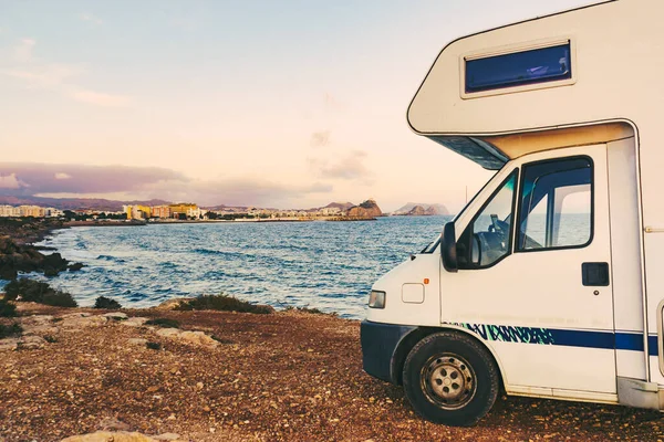Motor home on spanish coast sea shore. Aguilas city in the distance. Murcia region, Spain. Visiting warm winter travel destinations.