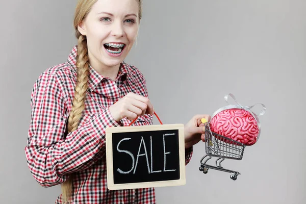 中に脳とショッピングカートを保持し 看板を販売幸せな女性 賢い責任ある購買コンセプト — ストック写真
