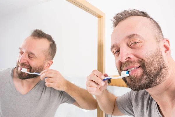 Взрослый Мужчина Чистит Зубы Глядя Зеркало Ванной Время Утренней Гигиены — стоковое фото