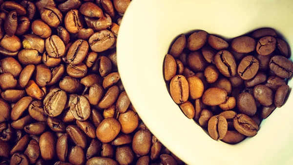 咖啡时间 在烤咖啡豆的底座上 有一个心形的白色杯子 顶部视图 — 图库照片