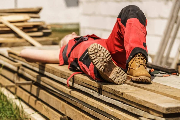 建筑工地上不认识的人穿着防护工作者的红裤 鞋底紧闭 — 图库照片