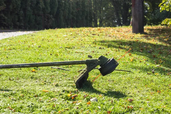 割草机躺在绿草上 季节性花园清洁运动物概念 — 图库照片