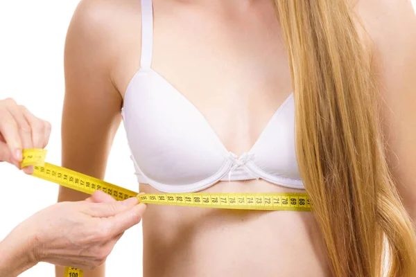 乳房の下で若い女性を測定する測定テープを持つ女性 ボスム ブラジャーフィッティングと下着のコンセプト — ストック写真