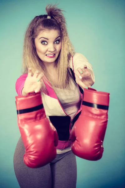 年轻女子厌恶地看着拳击手套 她不喜欢打架和挑衅 — 图库照片