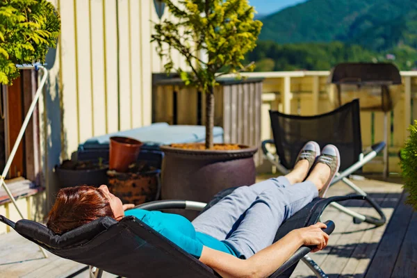 太陽の下でリラックス ベランダの屋外のデッキチェアで寛ぐ大人の女性 休日のコテージ — ストック写真