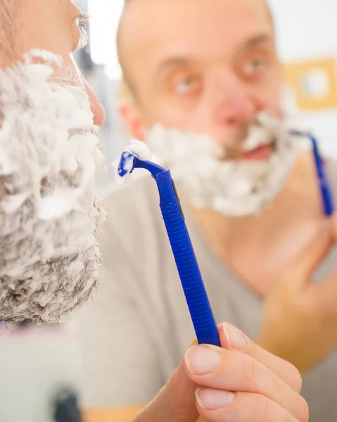 Mann Mit Viel Rasierschaum Gesicht Steht Badezimmer Schaut Den Spiegel — Stockfoto