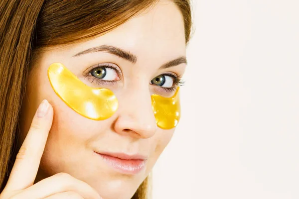 Jonge Vrouw Die Gouden Collageenvlekken Onder Ogen Aanbrengt Masker Verwijderen — Stockfoto