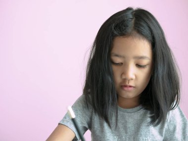 Dağınık kafa kız pembe arka plan ve kopya alanı olan bir kitap yazma