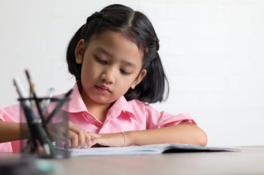 Çocuklar kullanım silgi bir sözcük silme. Yakın yukarı küçük kız ahşap masa üzerinde ödev yapıyor. Odak kopya alanı ile alan sığ derinliği seçin.