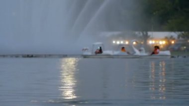 Bulanık insanlar halka açık parkta ördek teknesine biniyor.