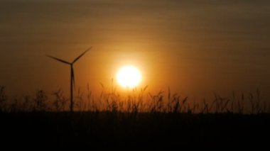 Alacakaranlık ile bulanık siluet rüzgar türbini ve çim alan