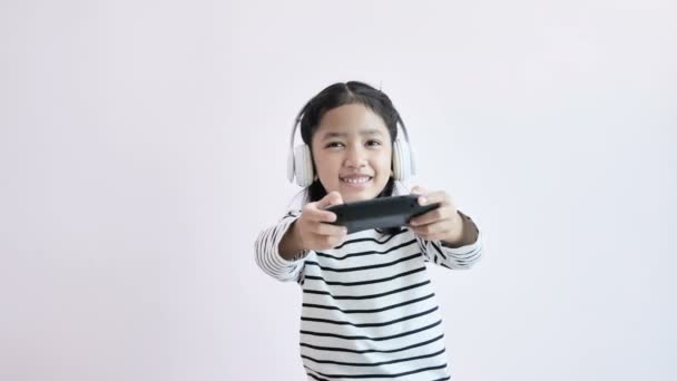 Κορίτσι Φορώντας Λευκά Ακουστικά Και Κρατώντας Joystick Παίζοντας Στο Παιχνίδι — Αρχείο Βίντεο