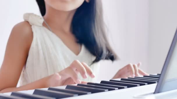 特写女孩穿着白色礼服弹钢琴与阳光在早晨和微笑与幸福 — 图库视频影像