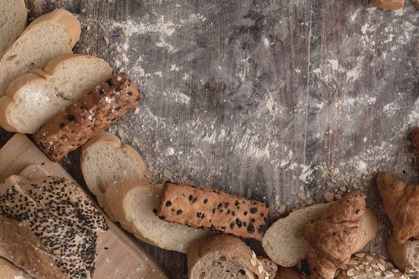 Pães e farinha de pastelaria em uma madeira — Fotografia de Stock