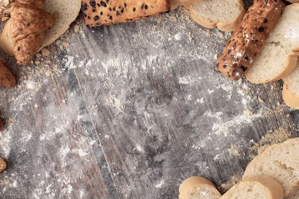 Pães e farinha de pastelaria em uma mesa de madeira — Fotografia de Stock