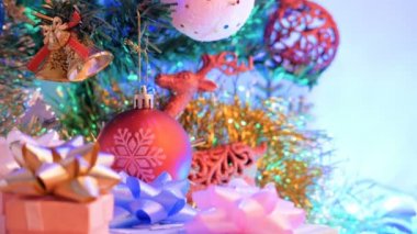 Masanın üzerinde hediye kutusu ile kırmızı Noel topu ve yanıp sönen ışık kapatın. Reindeer ile bulanık ve bokeh arka planlar.