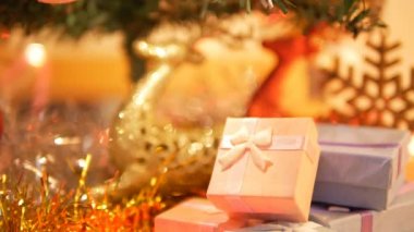 Bokeh arka planlar ile hediye kutusu ve yanıp sönen ışık. Noel konseptinde çam altında bulanık kırmızı ve altın reindeer.