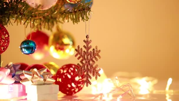 ウィンカー光の背景と松にぶら下がる雪片とクリスマスボール — ストック動画