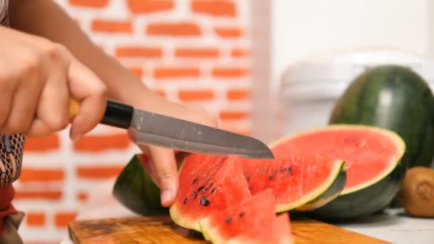 用小刀把西瓜切成割板上的馅饼 西瓜是一种具有凉爽特性的水果 这将有助于减轻疼痛 干咽喉 缓解口腔溃疡煮瓜片 — 图库视频影像