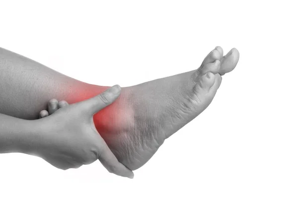 Mujer con dolor en el tobillo con la mano sosteniendo la pierna y masajeando el dolor —  Fotos de Stock