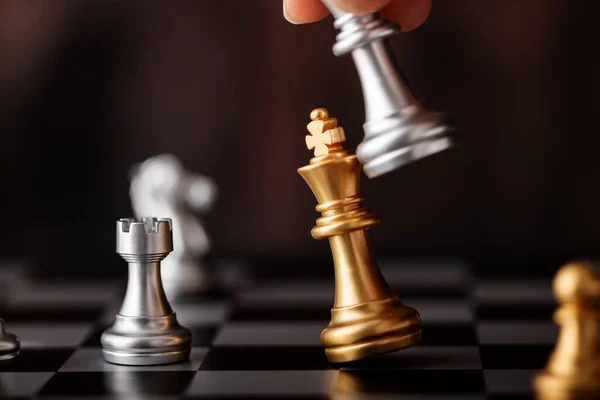 Hand Holding Silver King Attack Gold Leader Game Chessboard — Stock Photo, Image