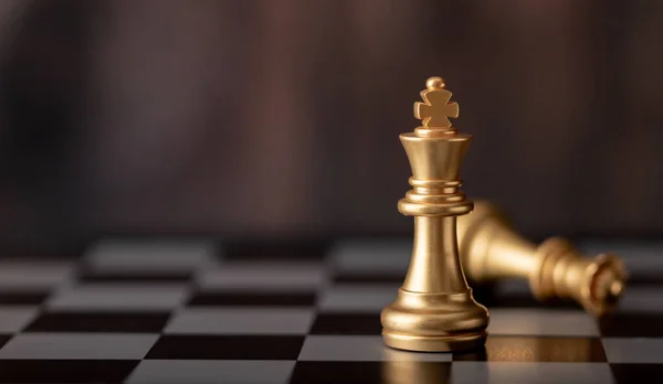 Altın kral ayakta ve kraliçe satranç tahtasına düşüyor.