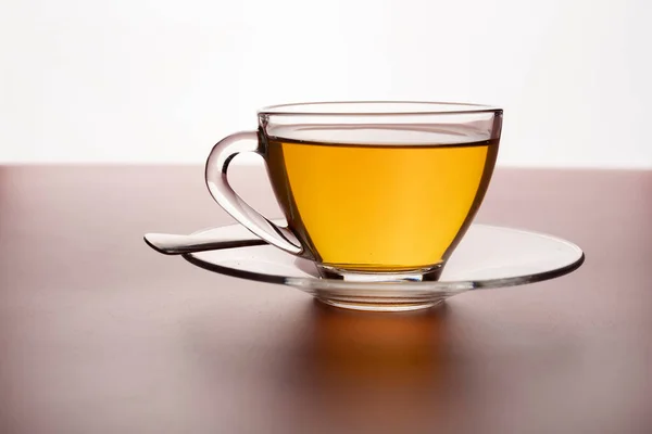 テーブルの上のガラスに淹れた熱いお茶のカップ — ストック写真