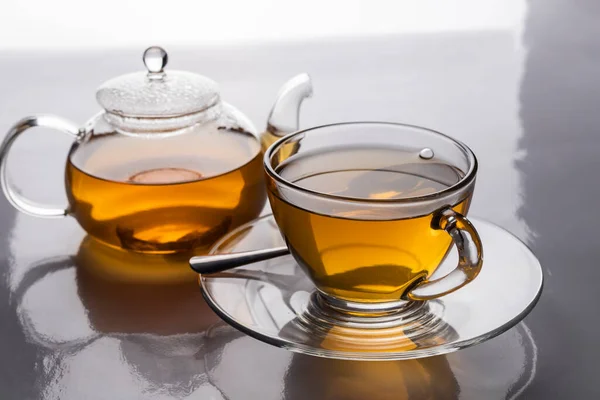 The hot teacup and teapot transparent on the table with copy space.