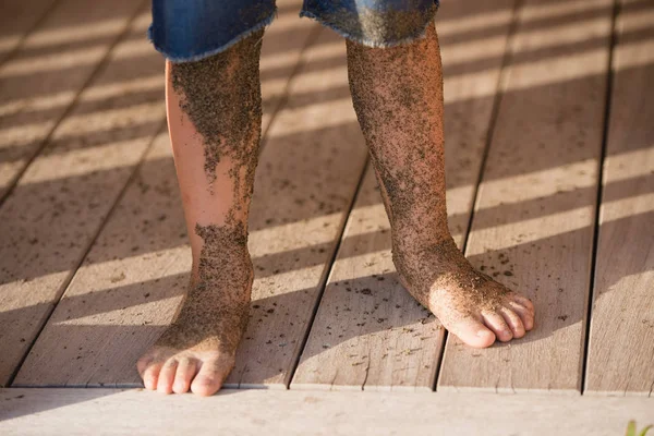 Jongens benen bedekt met zand van de zee Rechtenvrije Stockafbeeldingen